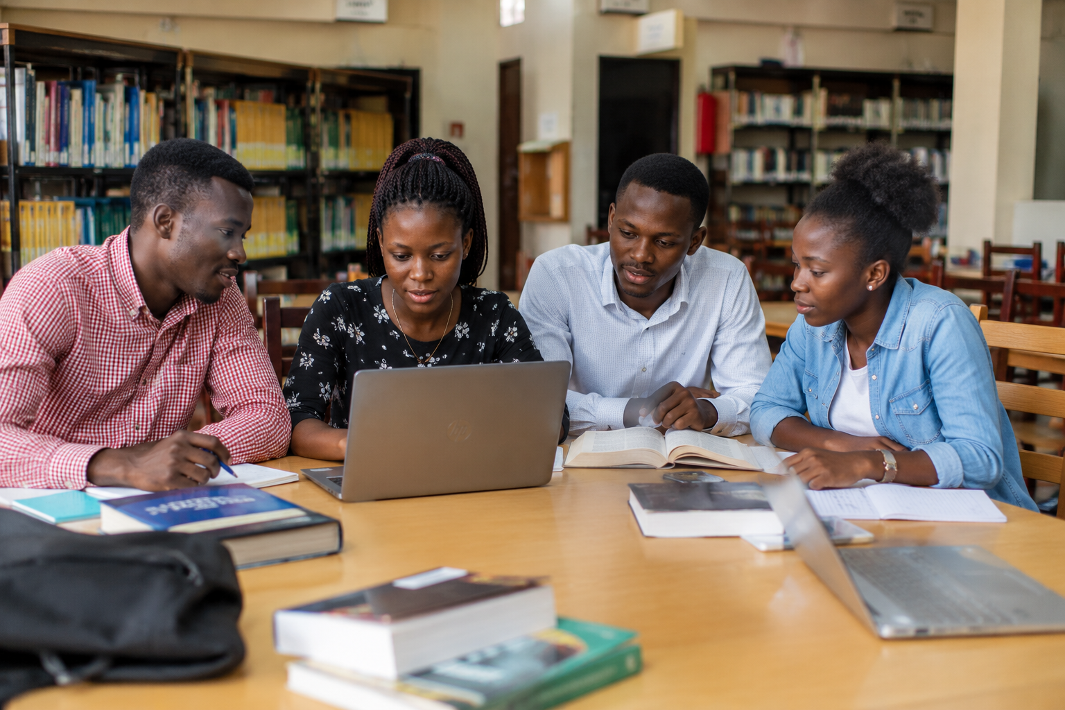 Busitema University students use digital and print resources during a collaborative study session, illustrating how the Library supports learning and research beyond the traditional bookshelves.